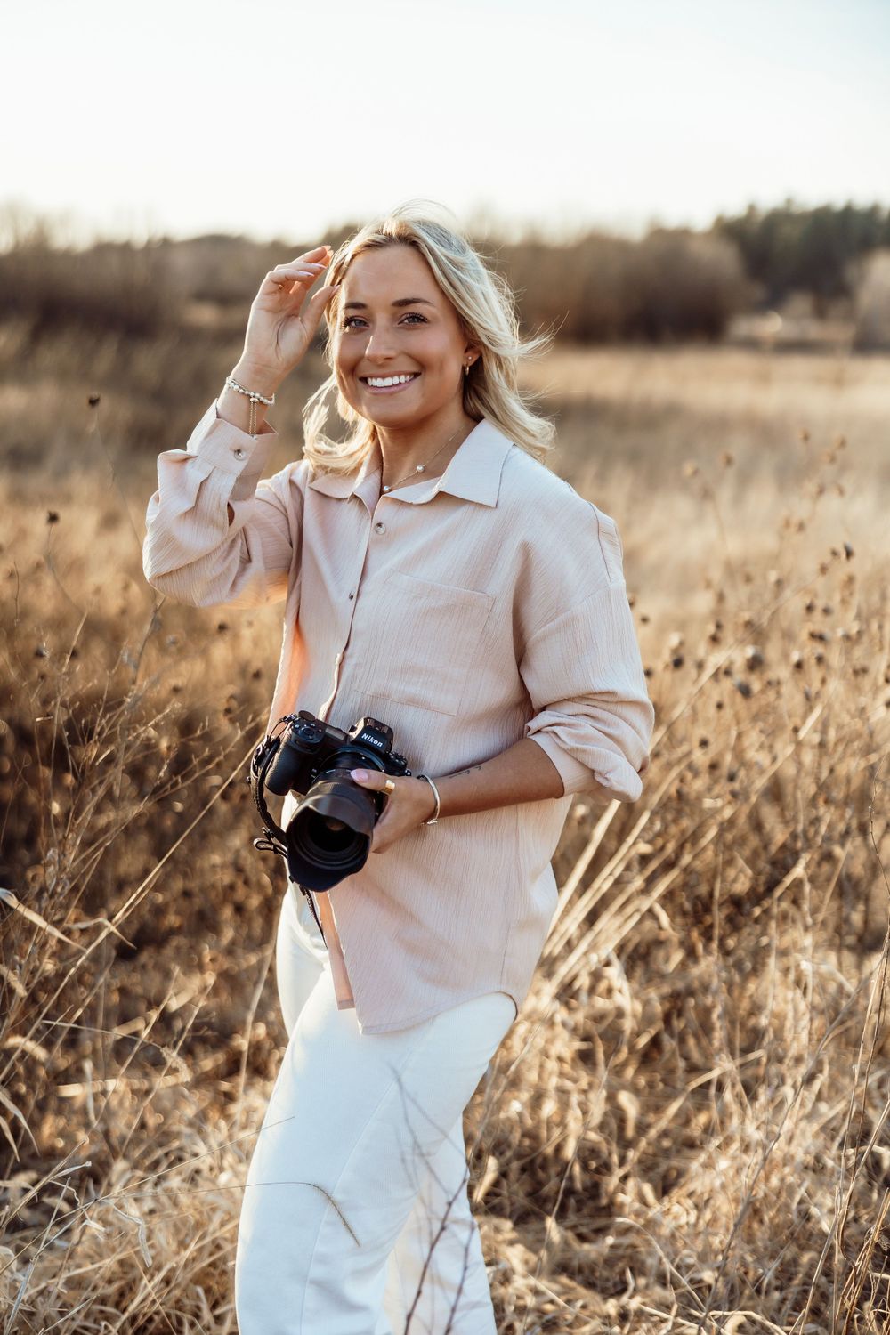 Photographer posing with camera, showcasing their passion for capturing memorable moments and stunning images.