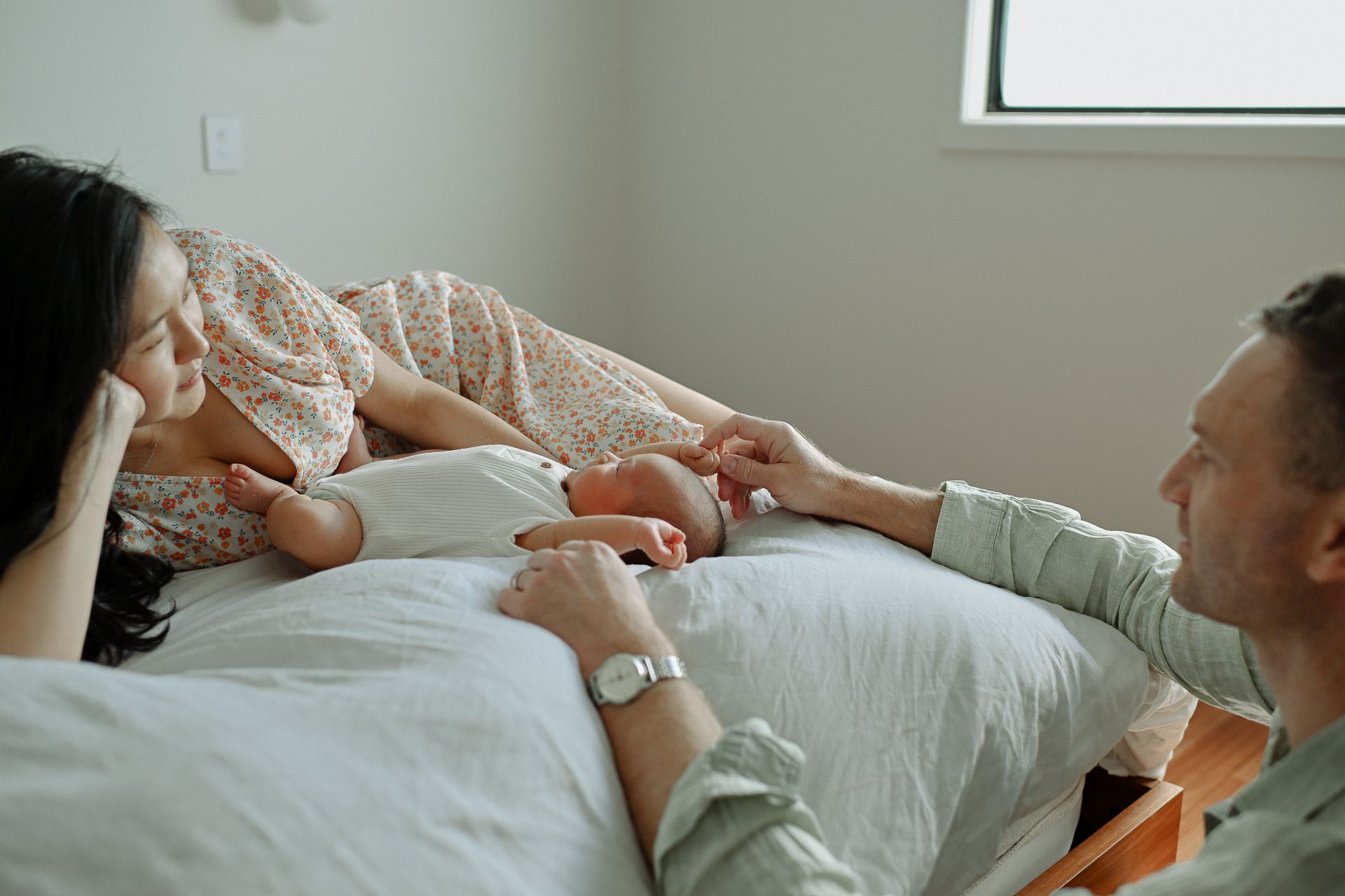 A person lies on a white bed while receiving a professional facial massage treatment at a spa.