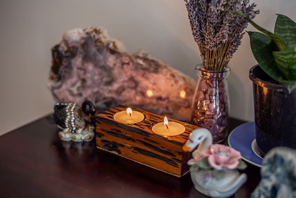 Wooden candle holders with lit candles create a cozy atmosphere alongside crystals and decorative elements.