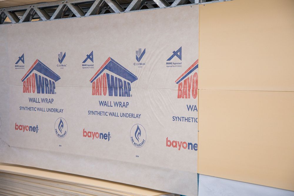 Bayonet wall wrap synthetic wall underlay installed on a building exterior, showing brand logo and product details.