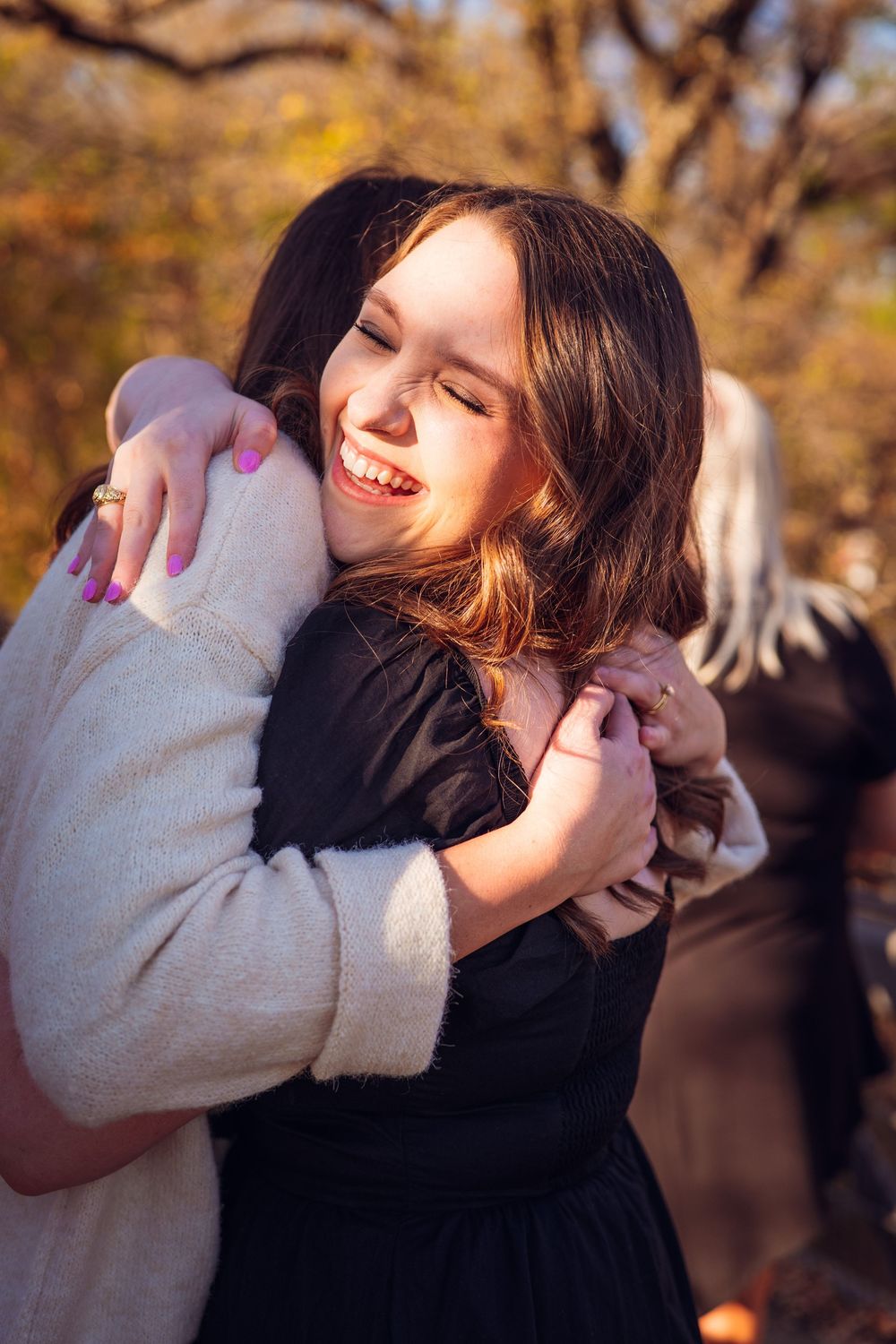A romantic embrace captured in warm autumn sunlight with soft focus and natural lighting.