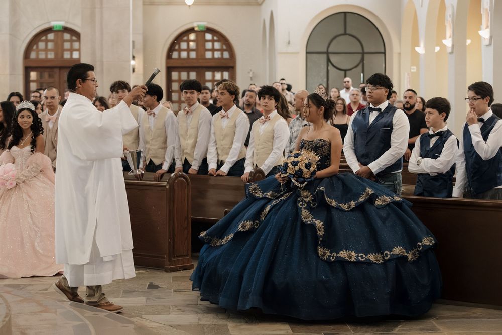 Couples dressed in traditional navy blue and white formal attire dancing during a wedding celebration in an ornate room.