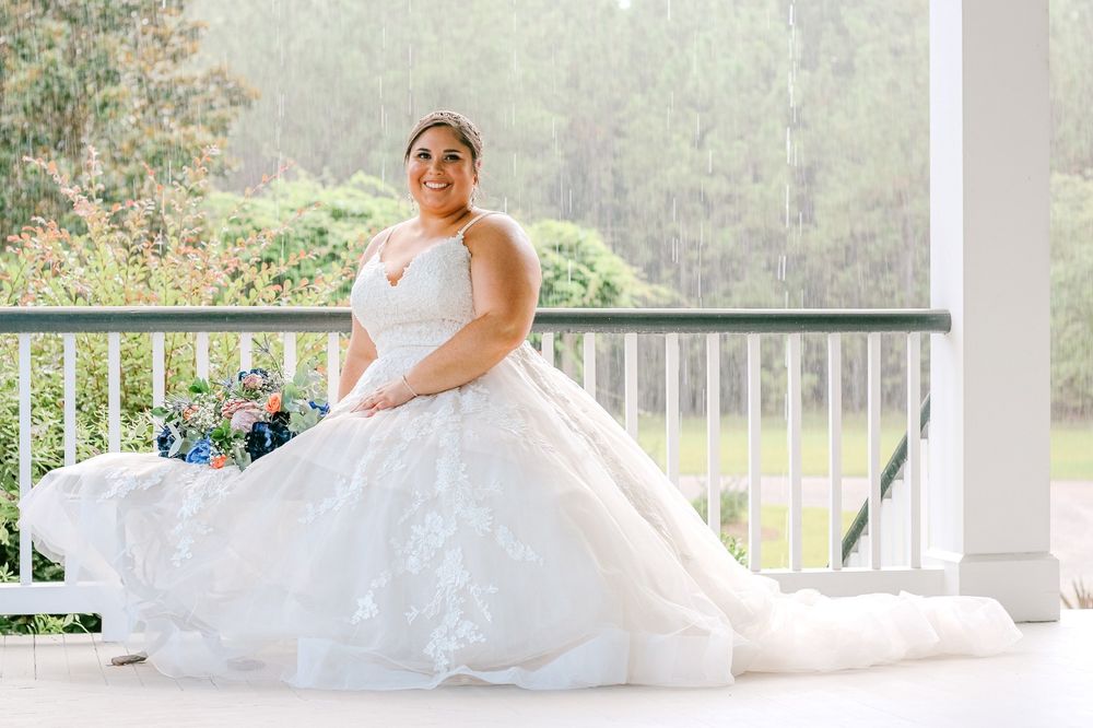 Bridal portrait on white porch with scenic mountain view in background.
