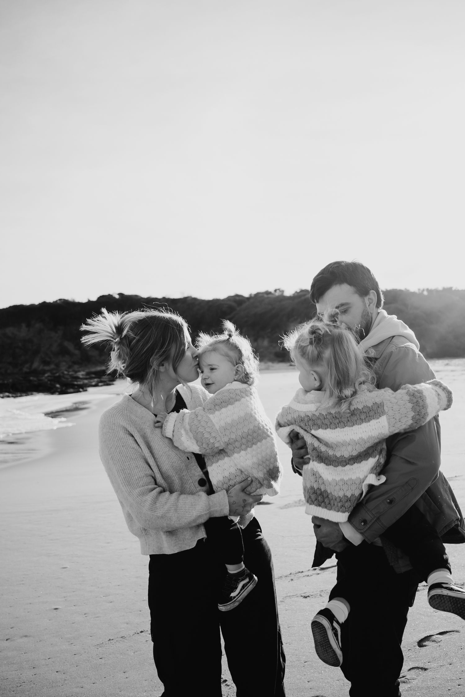 Family standing together at the beach.