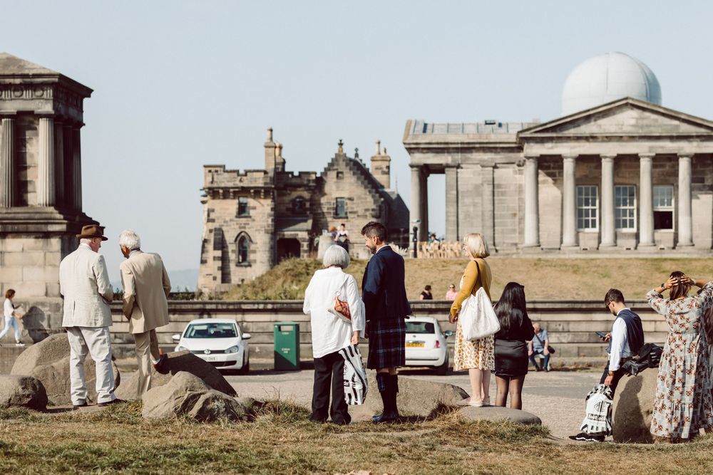 Tourists exploring the historic monuments and architecture on Calton Hill.