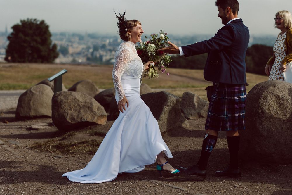 Romantic wedding photoshoot among large boulders with scenic overlook.