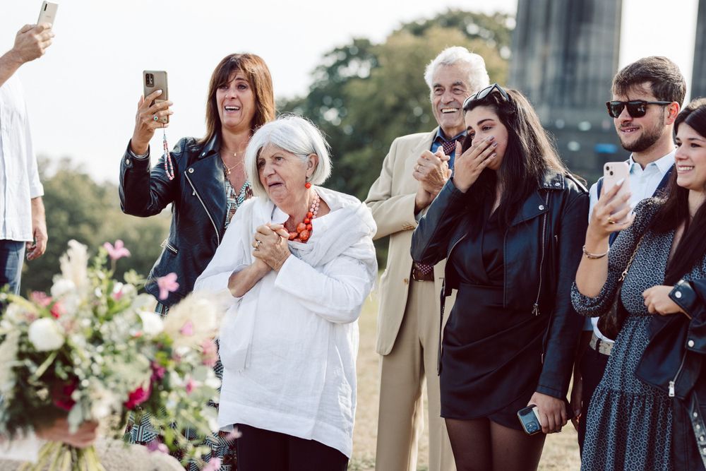 Wedding attendees taking photos and celebrating during outdoor reception.