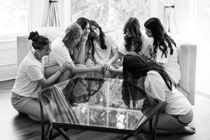 Wedding guests laugh and share stories while sitting at tables during an intimate reception celebration.