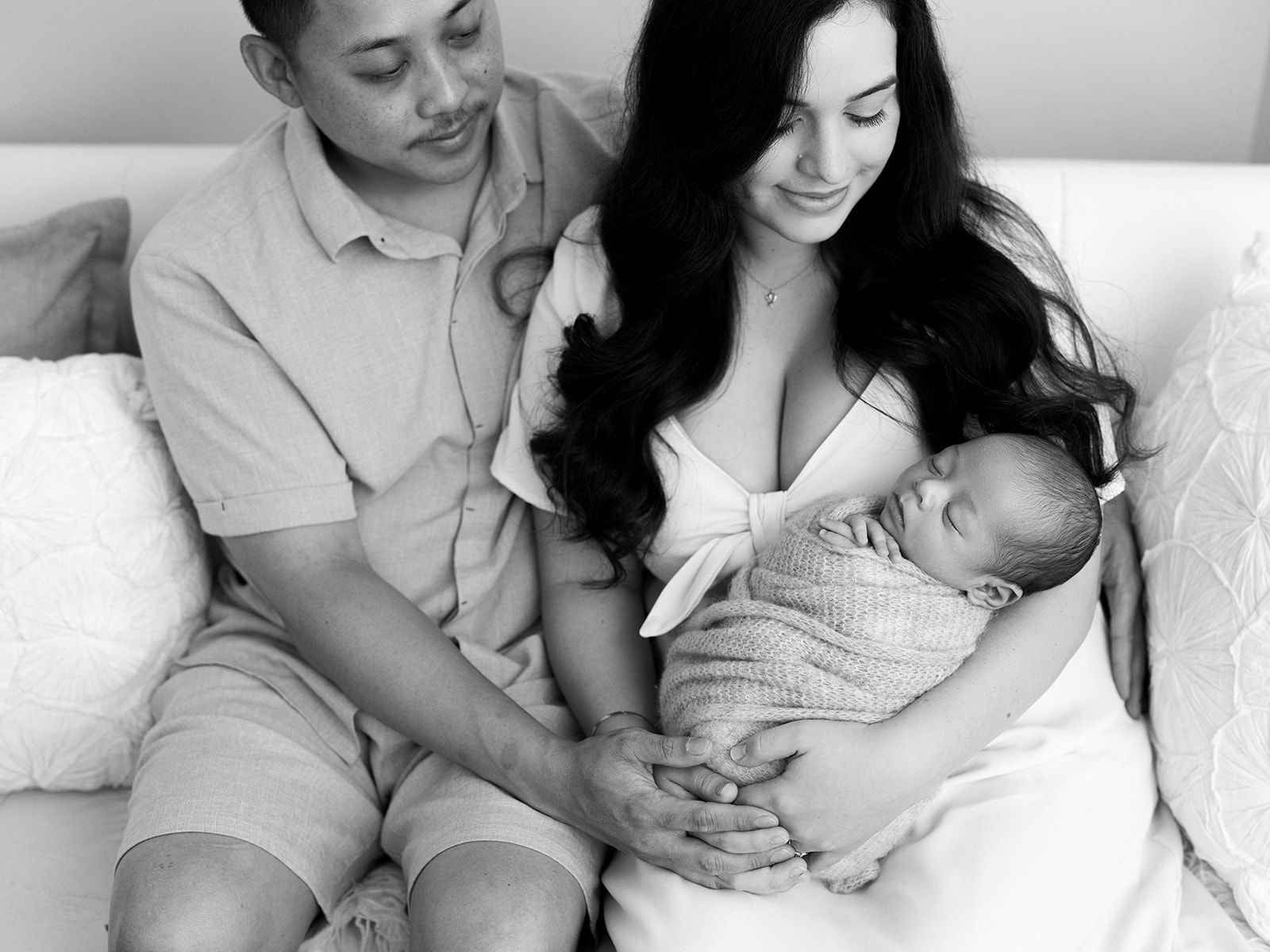 A series of tender moments showing parents bonding with their newborn baby in black and white photographs.