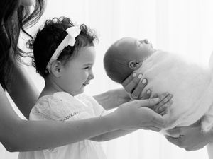 A series of black and white photos showing tender moments between a parent and child in intimate poses.
