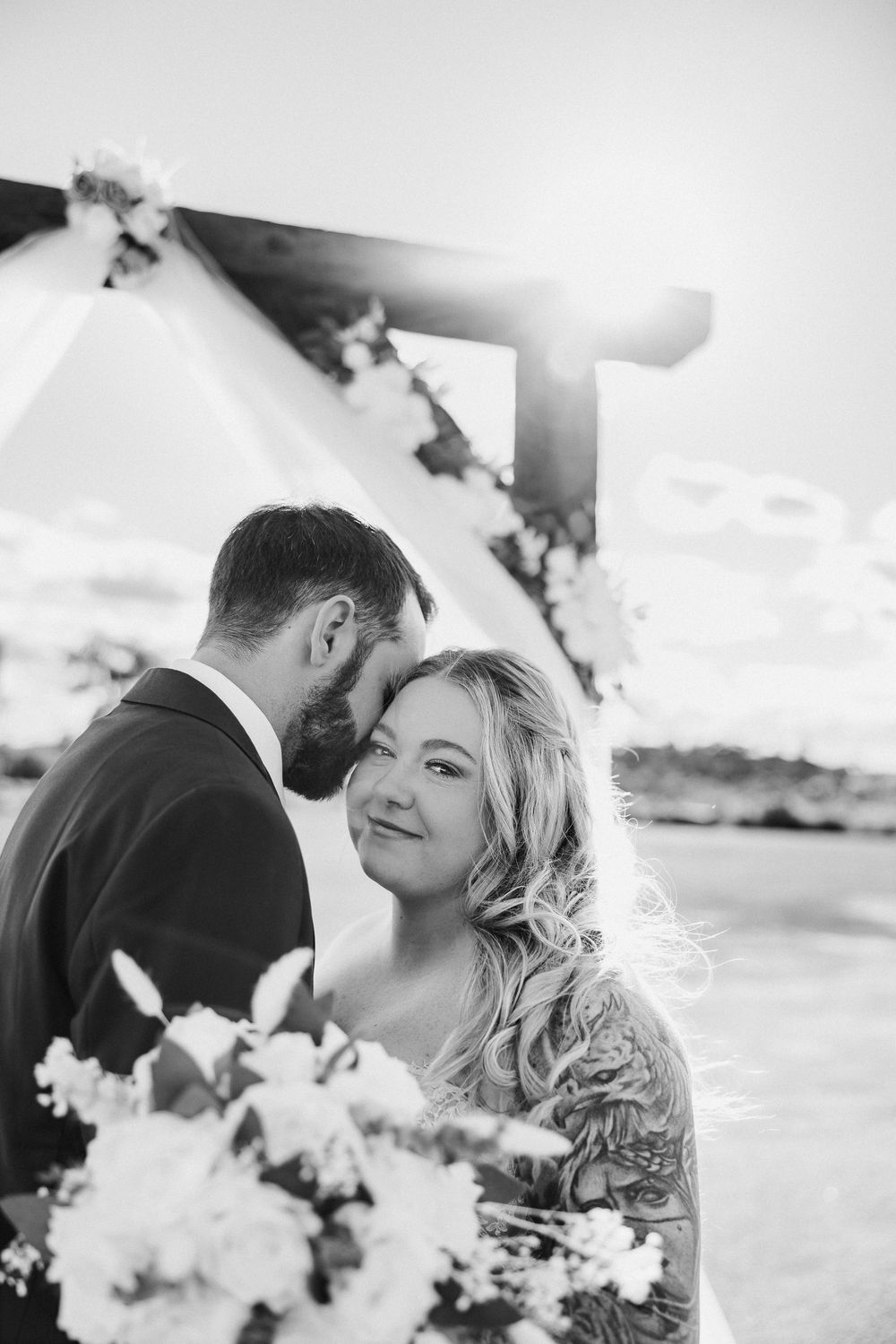 A romantic black and white wedding photo series captures intimate moments between newlyweds.