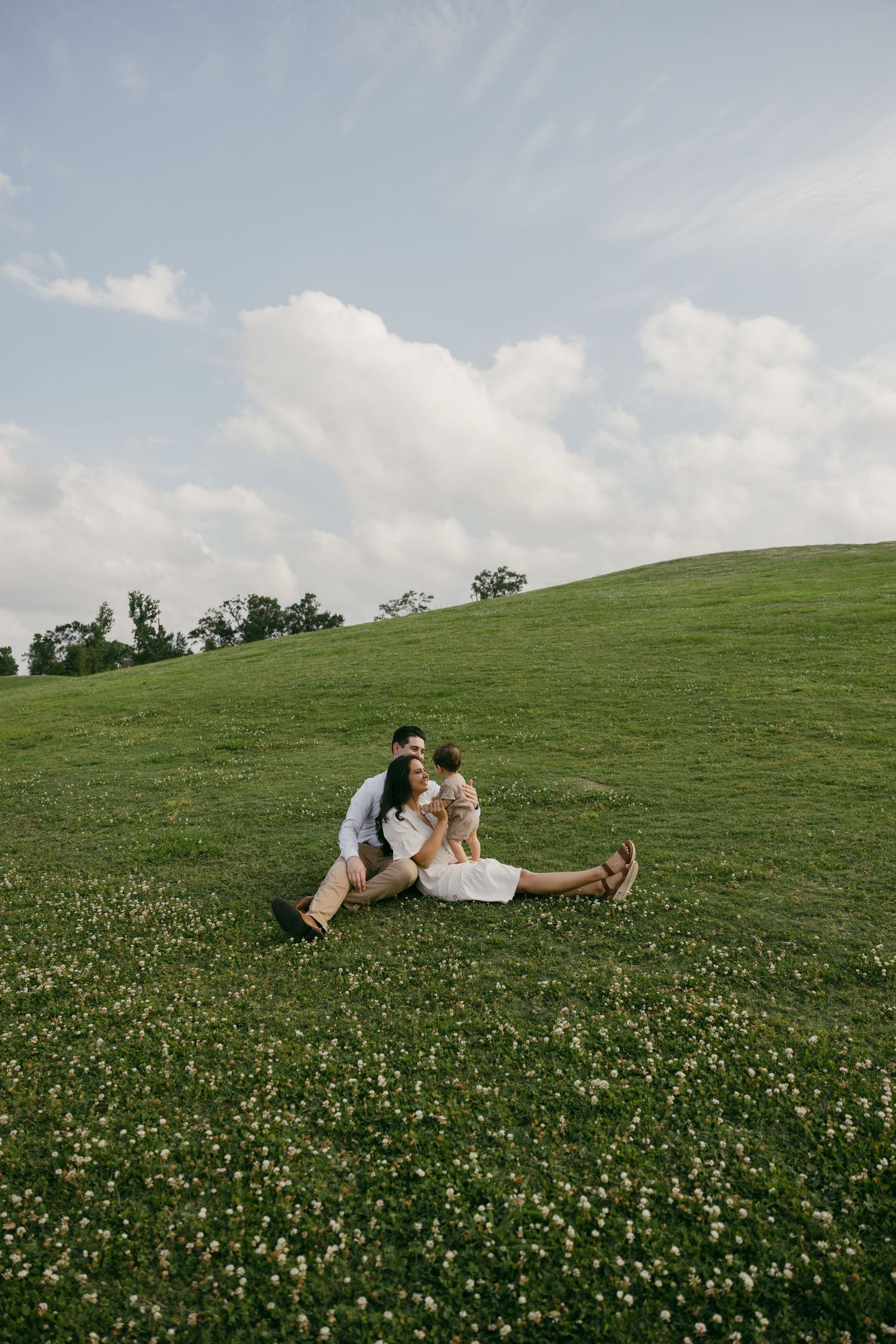 A couple dancing and twirling together on a dirt path surrounded by tall grass and trees.