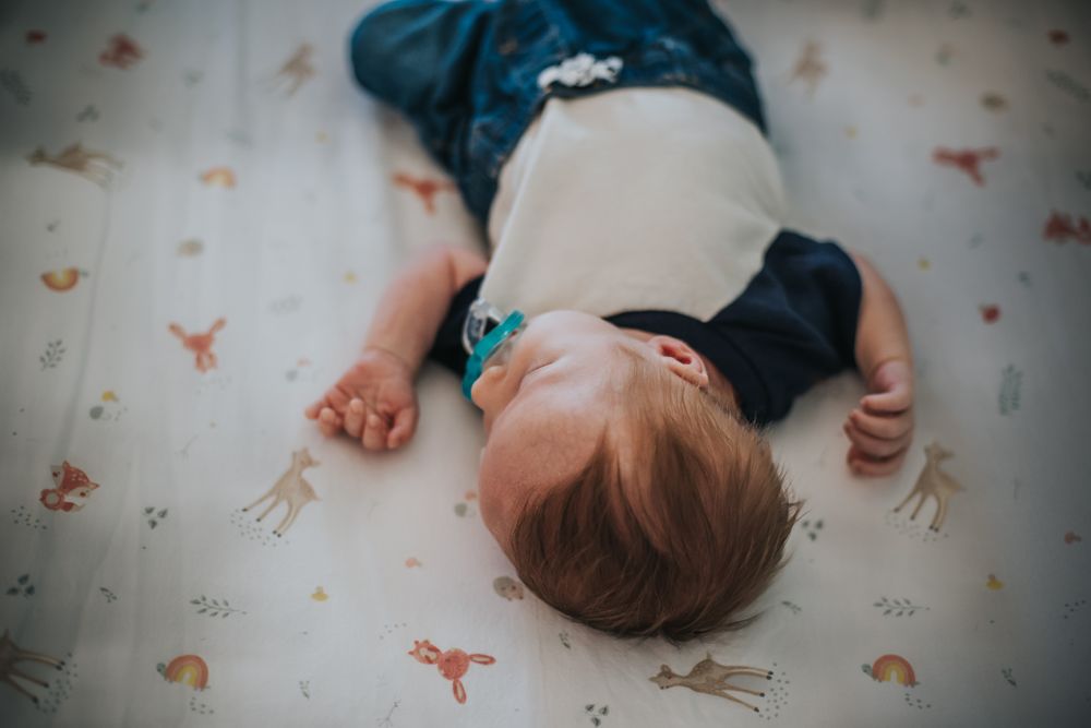A newborn lays in his crib.