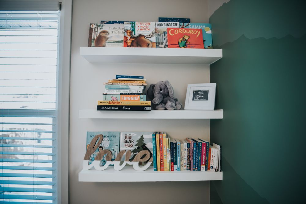 Adorable shelves of books for babies in the nursery with a wooden sign of the word 'love'.