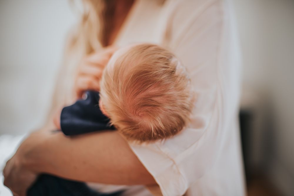 The back of a baby's head, focus on his strawberry blond locks.