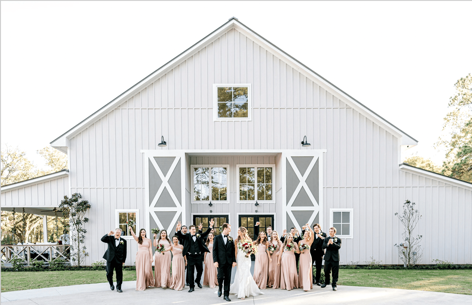 Bridal party walking and laughing in front of Addison Woods wedding venue.
