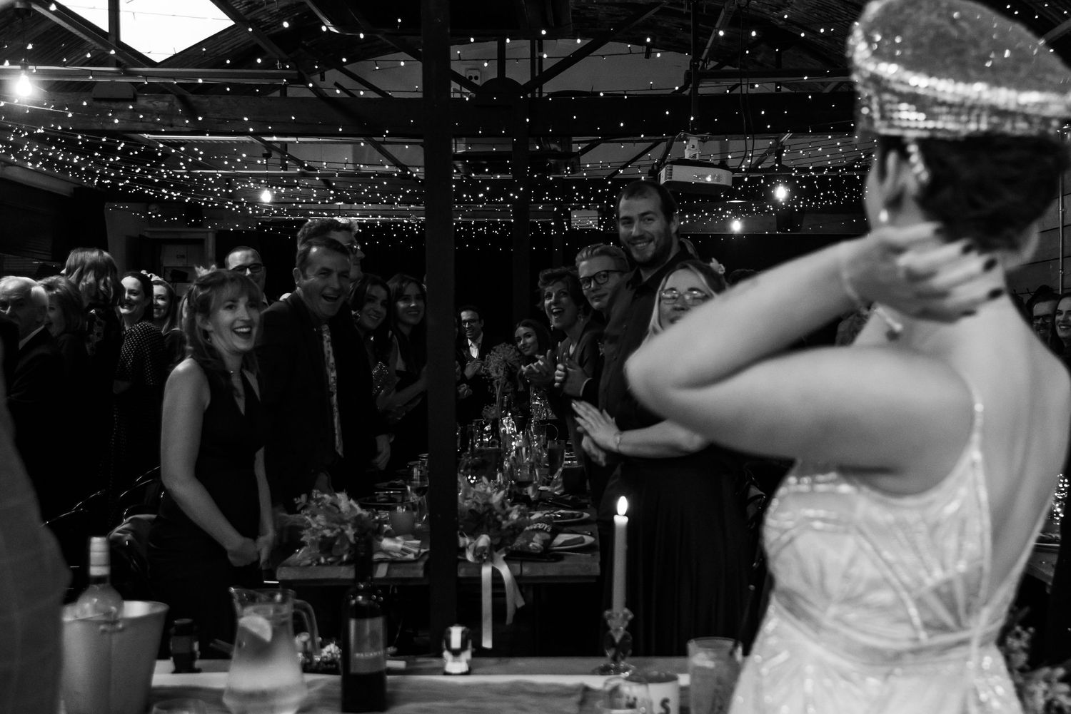 Dark silhouettes of wedding guests dancing under ambient lighting.