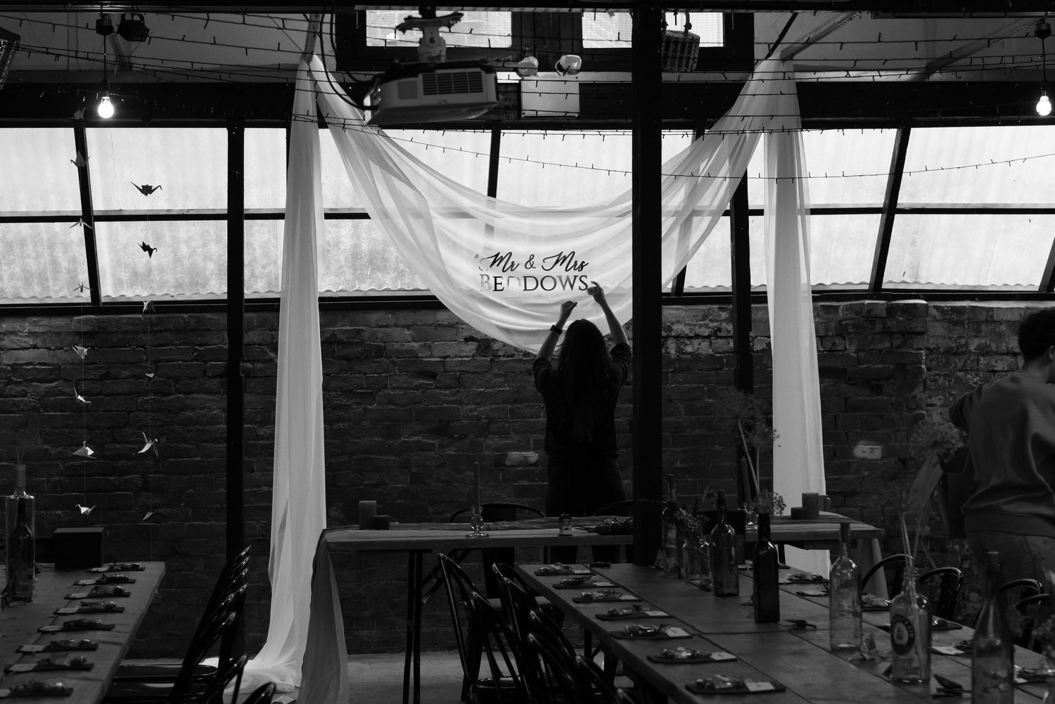 Empty wedding venue interior with exposed beams and natural lighting.