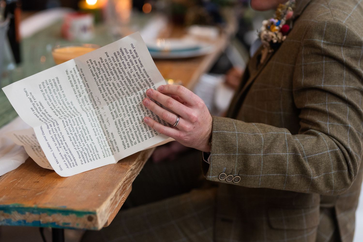 Close-up of hands holding wedding ceremony readings or vows on paper.