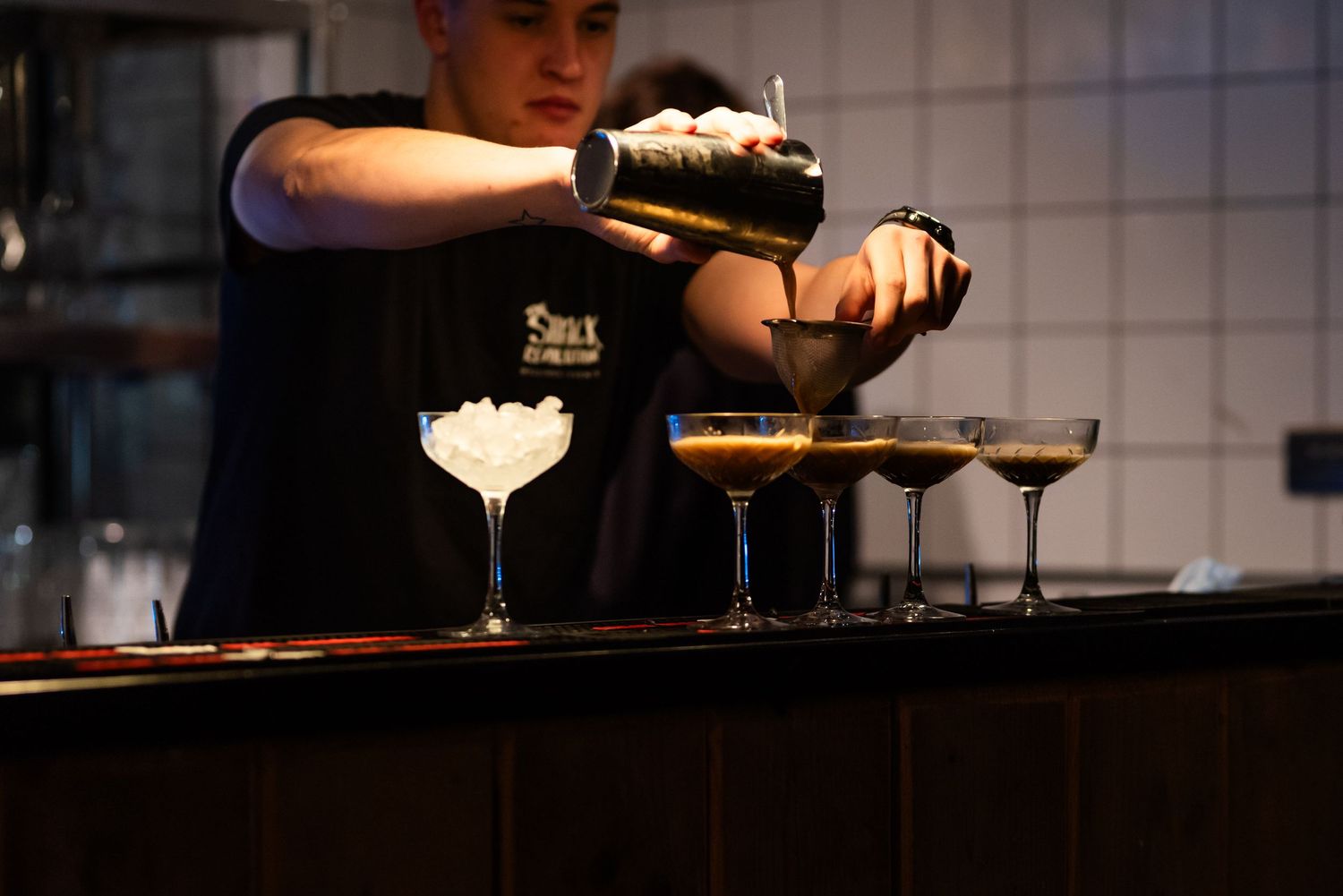 Bartender preparing cocktails at an elegant bar setup.
