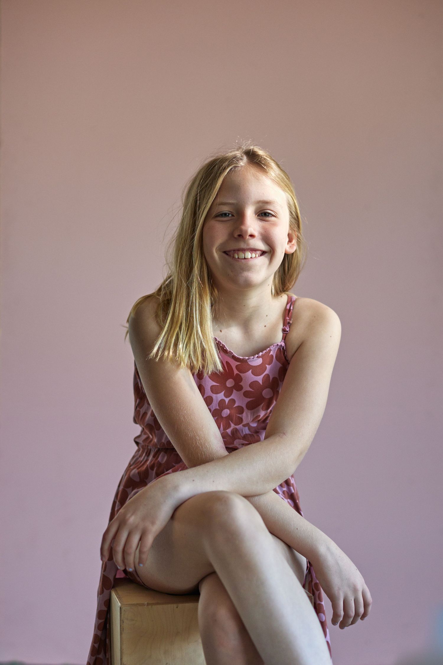 Candid lifestyle portraits showing joyful expressions in pink floral dress.