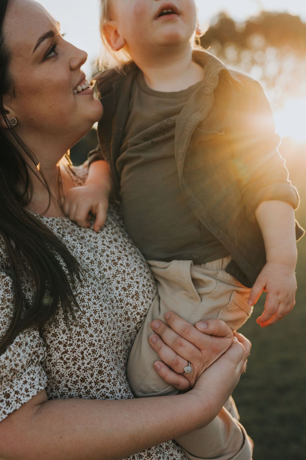 Tender family moments captured in golden sunlight during an outdoor photo session.