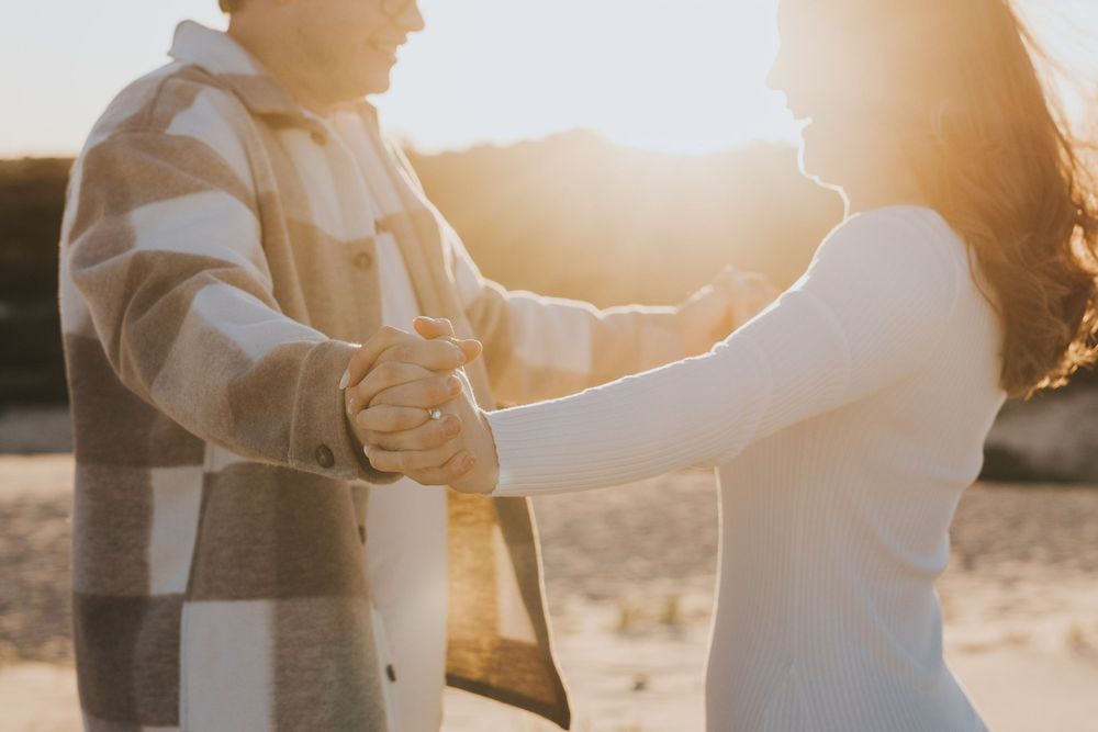 Silhouetted couple embracing during golden hour sunset.