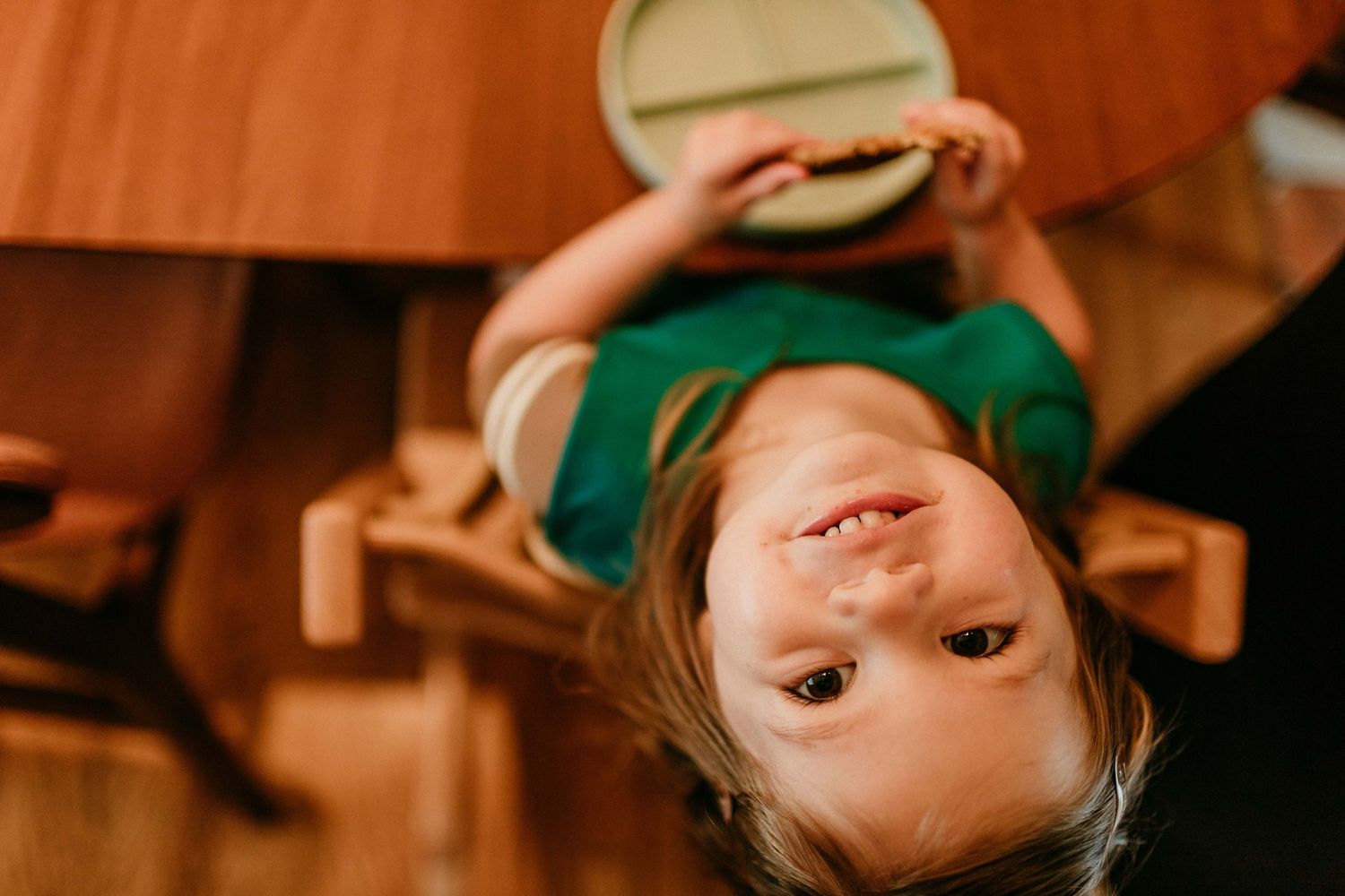 child looks upside down at camera portland oregon family photographer rushes & waves