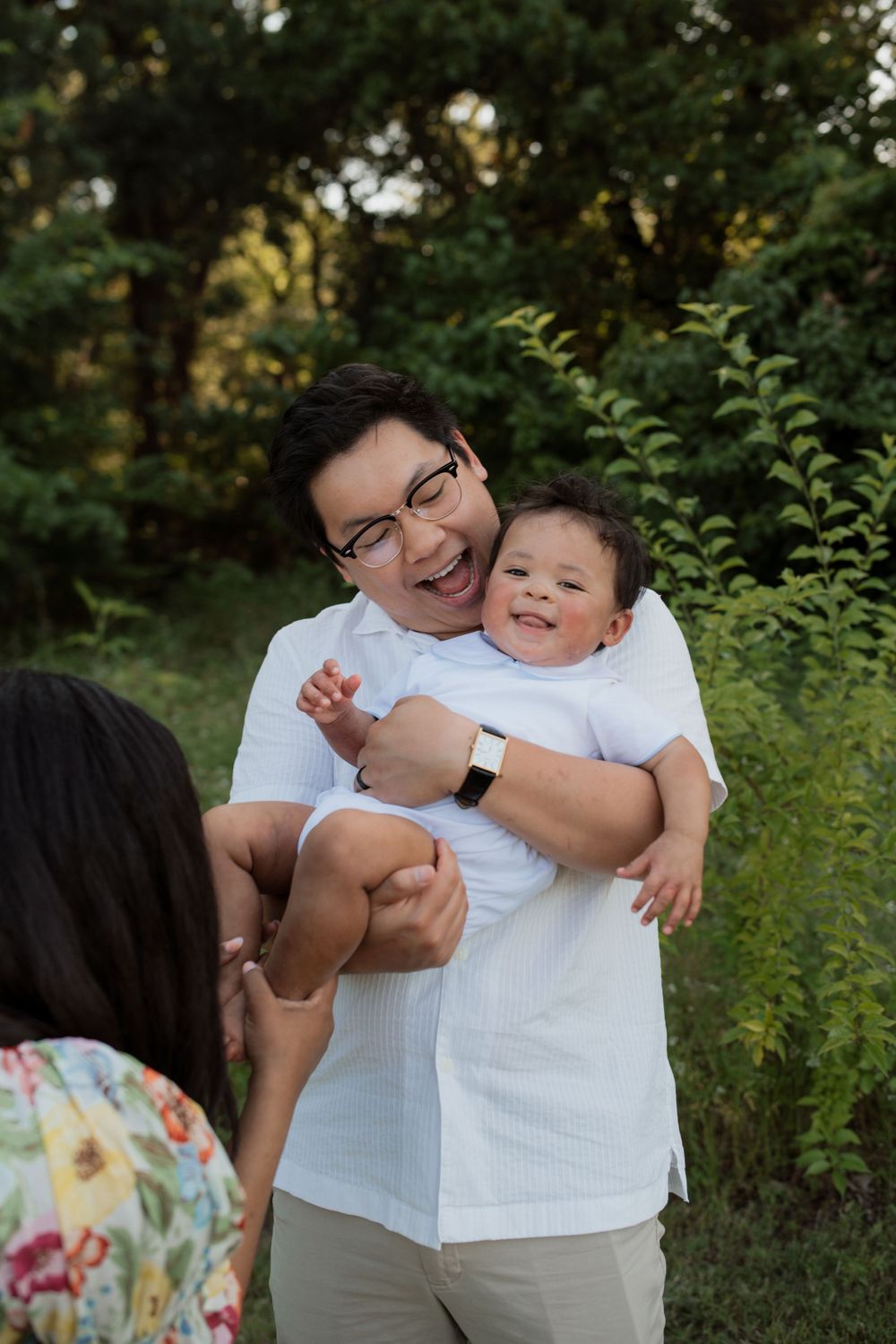 A series of candid family portrait moments captured outdoors in a natural setting with greenery.