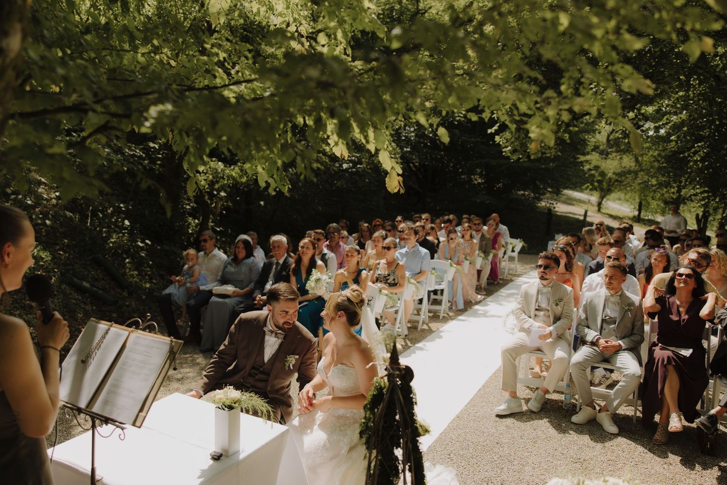 A couple shares a tender moment outdoors in warm natural lighting.