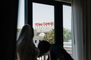 View from a window of the iconic Vine Street sign in Hollywood, CA, with two people in the foreground.