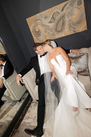 A romantic wedding dance sequence showing a couple performing a dip move in formal attire against a dark background.