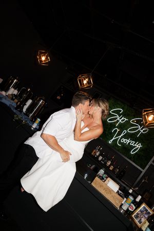 A person in a white shirt dancing or moving dynamically in a dimly lit room with low-light effects.