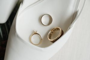 Three wedding rings arranged on white fabric with contrasting textures and minimalist aesthetic design.