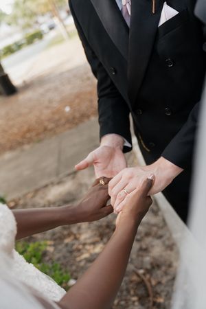 Close-up of hands during a wedding ceremony as bride and groom exchange rings.