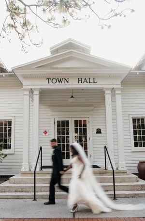 Sequence of wedding photos showing a couple entering a white-sided town hall building with traditional colonial architecture.