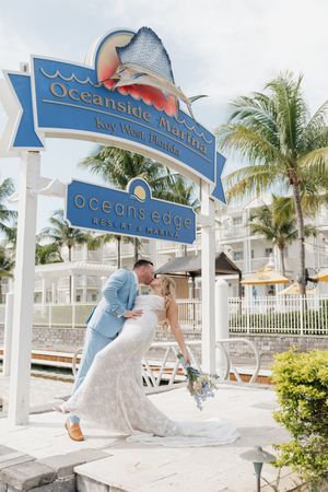 A series of five connected images showing a wedding couple posing under blue and white Oceanside Marina signs at a resort.