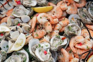 Fresh seafood platter with oysters, shrimp, and lemon garnish on ice.