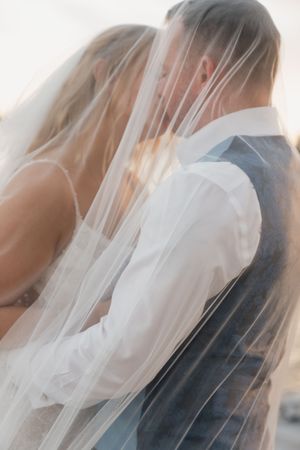 Soft focus close-up of bridal veils with ethereal lighting creating a dreamy effect.
