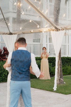 A sequence of wedding photos under a white tent with string lights and garden backdrop.