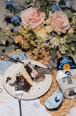Wedding reception details with pink roses, cake, and drinks on a decorated table.