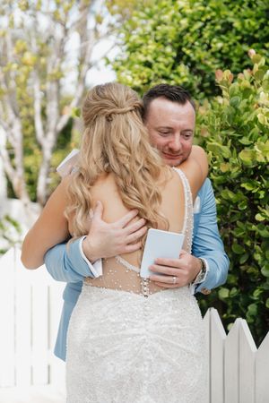 A tender emotional moment captured in a garden setting with white picket fence in the background.