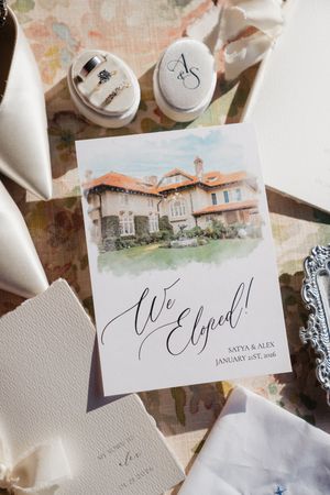 Elegant wedding invitation suite featuring watercolor venue illustrations and calligraphy on textured paper.
