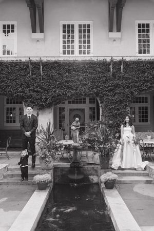 Black and white photo of an elegant wedding venue with ivy-covered walls and reflecting pool.