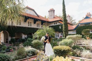 Mediterranean-style venue with palm trees and Spanish architecture for outdoor wedding.