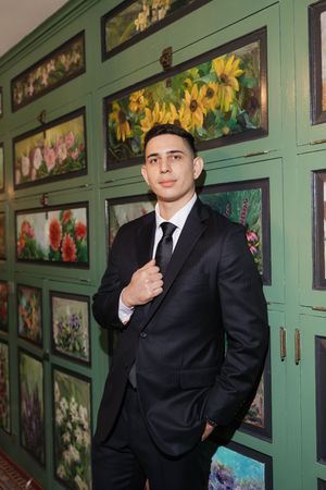 A series of formal portraits taken against a green wall with decorative framed artwork.