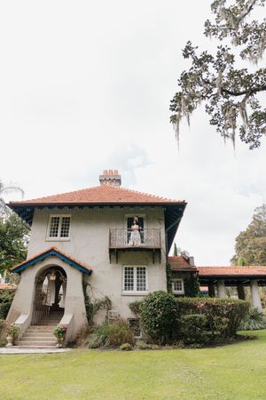 A panoramic view of a Spanish colonial style mansion with white walls and terracotta roof tiles.