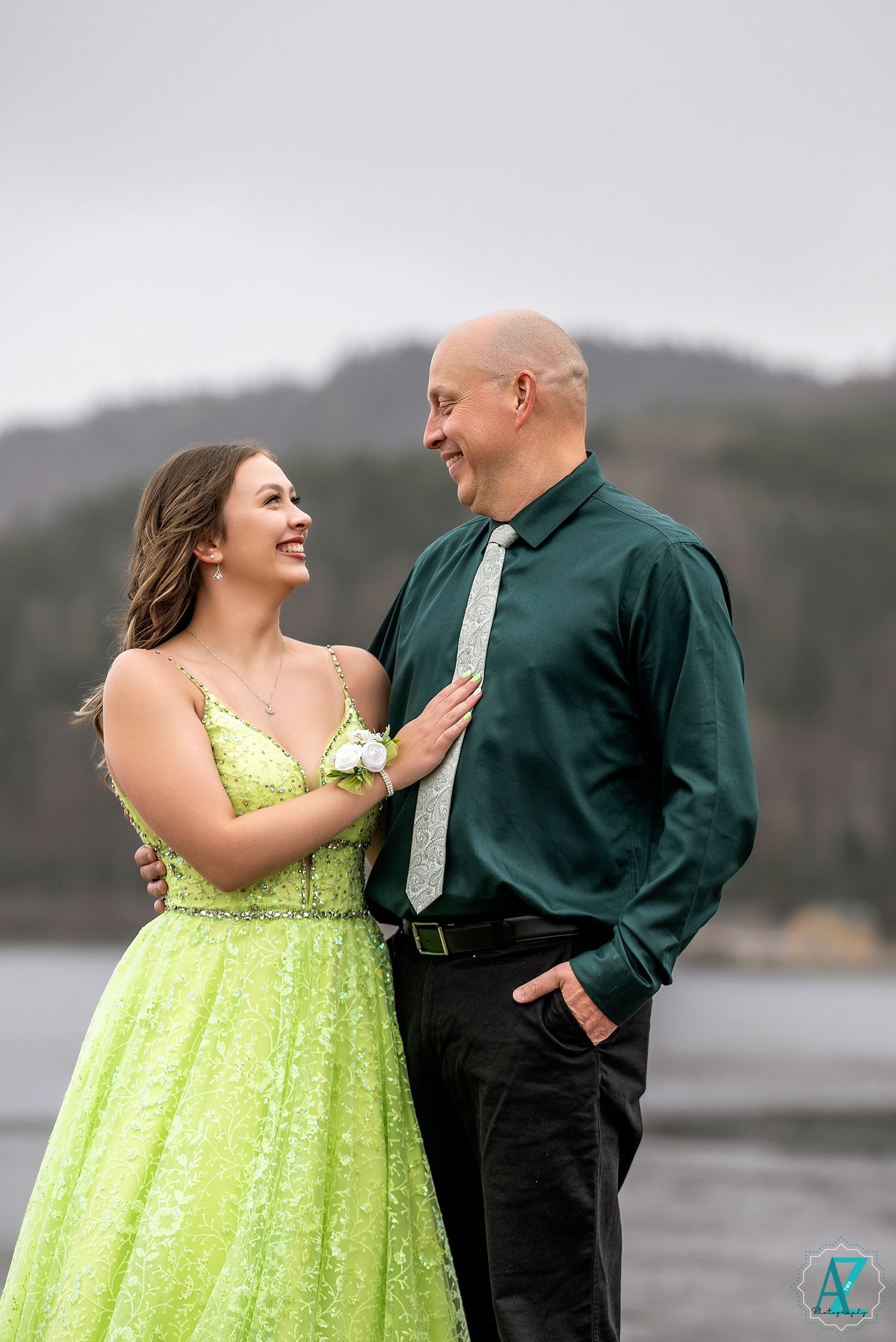 A couple shares a joyful moment outdoors, with the woman wearing a bright lime green sparkly formal gown.