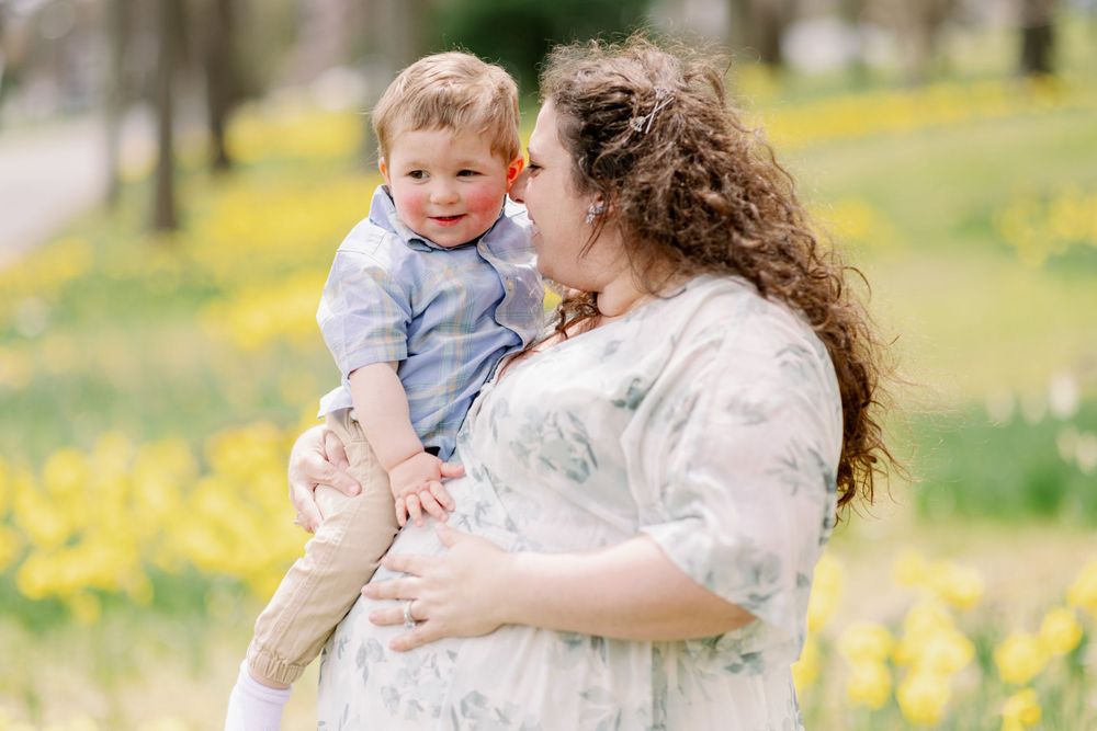 A spring portrait among daffodils in a sunny park setting.