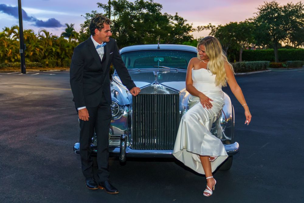 Bride and groom embracing with glowing Hard Rock Guitar Hotel in the night sky background, romantic South Florida wedding portrait